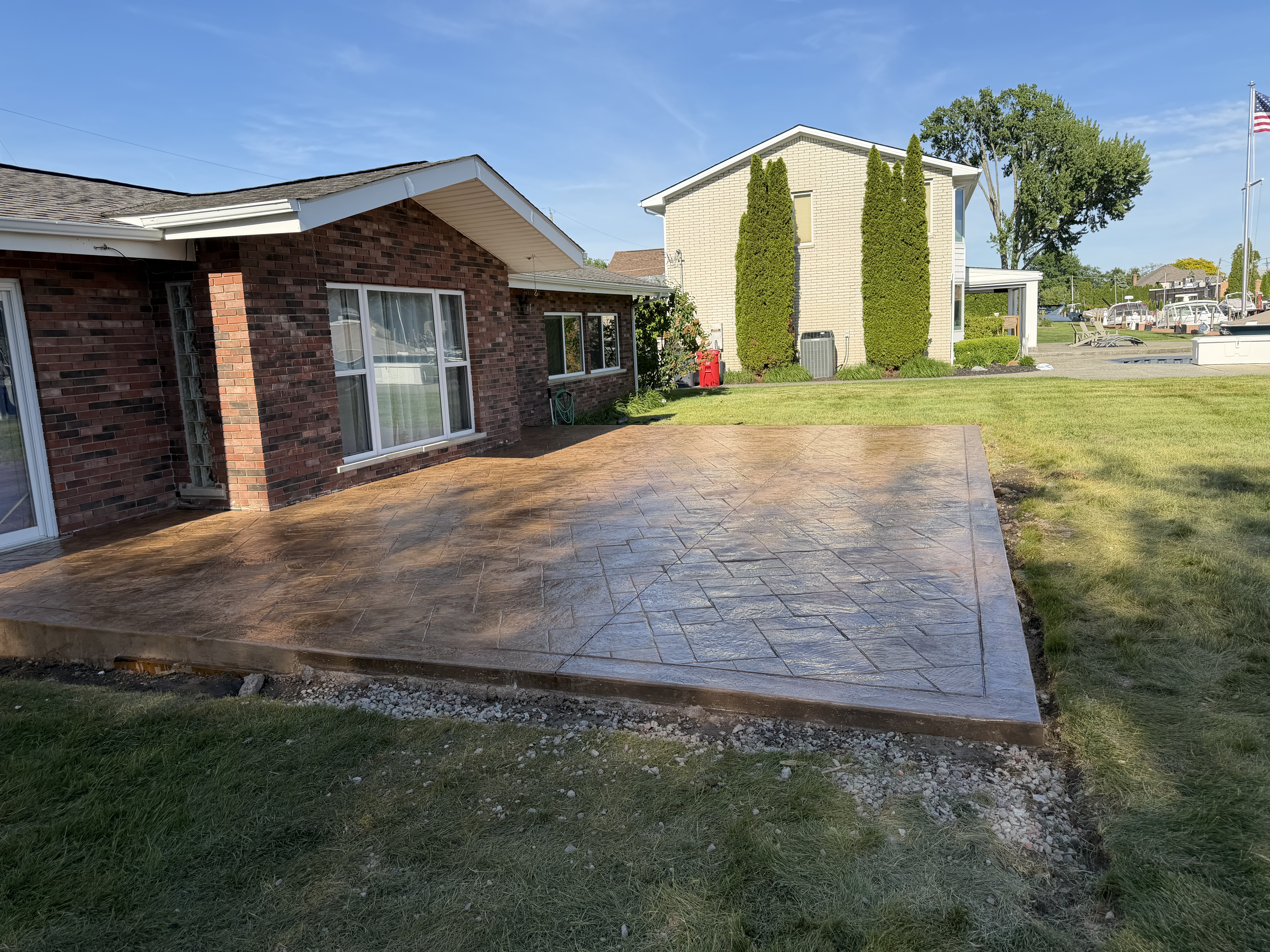 Stamped concrete patio at lakefront home by Mitten Made Concrete